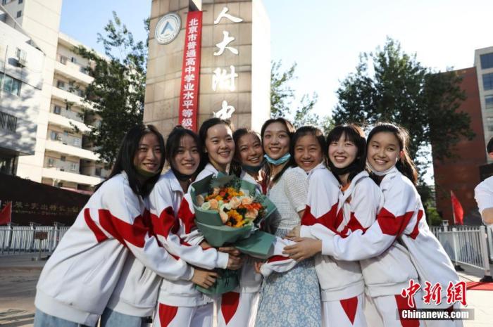 资料图：6月10日，在北京人大附中高考考点外，考生们相拥拍照留念。当日，北京市2021年高考结束。　 <a target='_blank'  data-cke-saved-href='http://www.chinanews.com/' href='http://www.chinanews.com/'><p align=