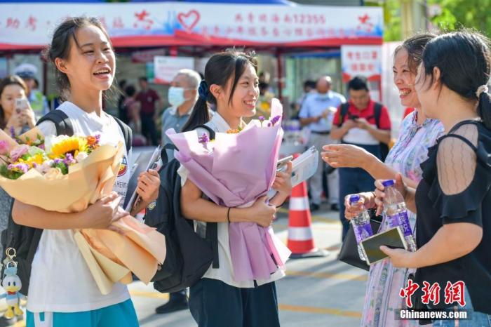 资料图：6月10日，海南省海口市海南中学考点外，家长为刚刚走出考场的考生送上鲜花。当日，海南省2021年高考结束。 <a target='_blank'  data-cke-saved-href='http://www.chinanews.com/' href='http://www.chinanews.com/'><p align=